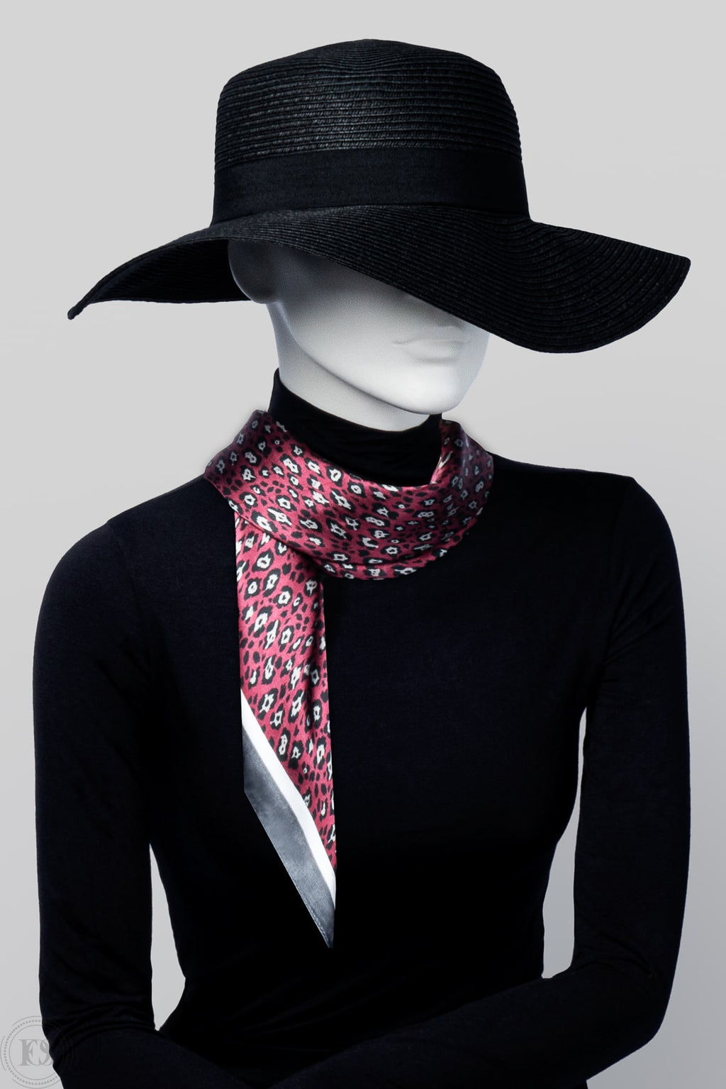 En lekfull scarf i röd, vit och grå leopardmönstrad. viras runt modells hans på ett stilrent sätt.