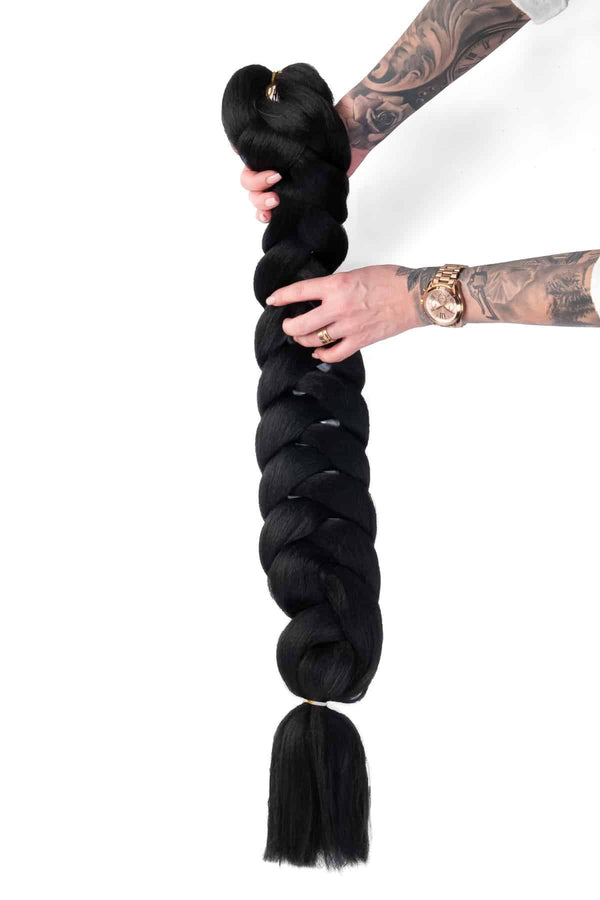 Produktbild på box braids i svart, där håret är flätat i jämna, separerade sektioner för en stilren och voluminös look