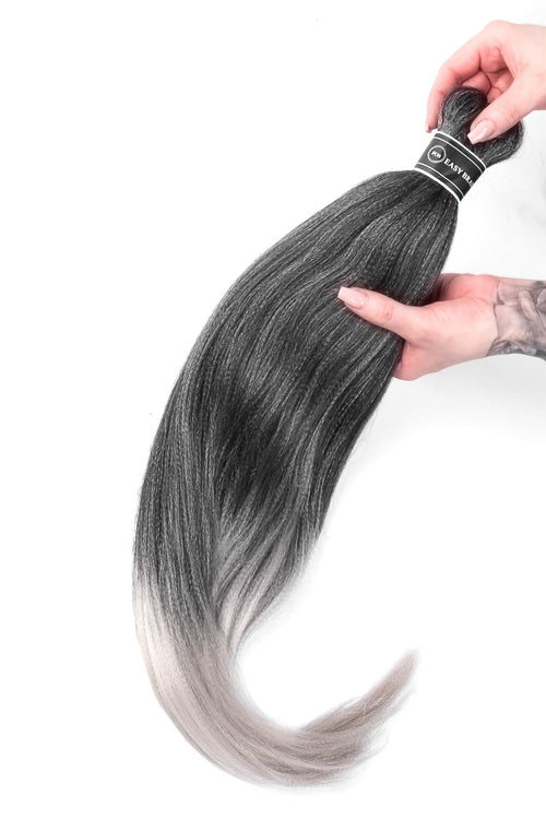 Bild på syntetiska easy braids i en svart och vit ombre-färg, där flätorna är mjuka och jämnt formade för en livfull och modern stil.