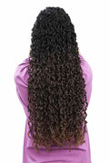 Modell med Långt majesty twist dreads. Långt lockigt hår i mörk ombrébrun ton med täta, spiralformade lockar som faller naturligt från mörka rötter till ljusare bruna toppar.