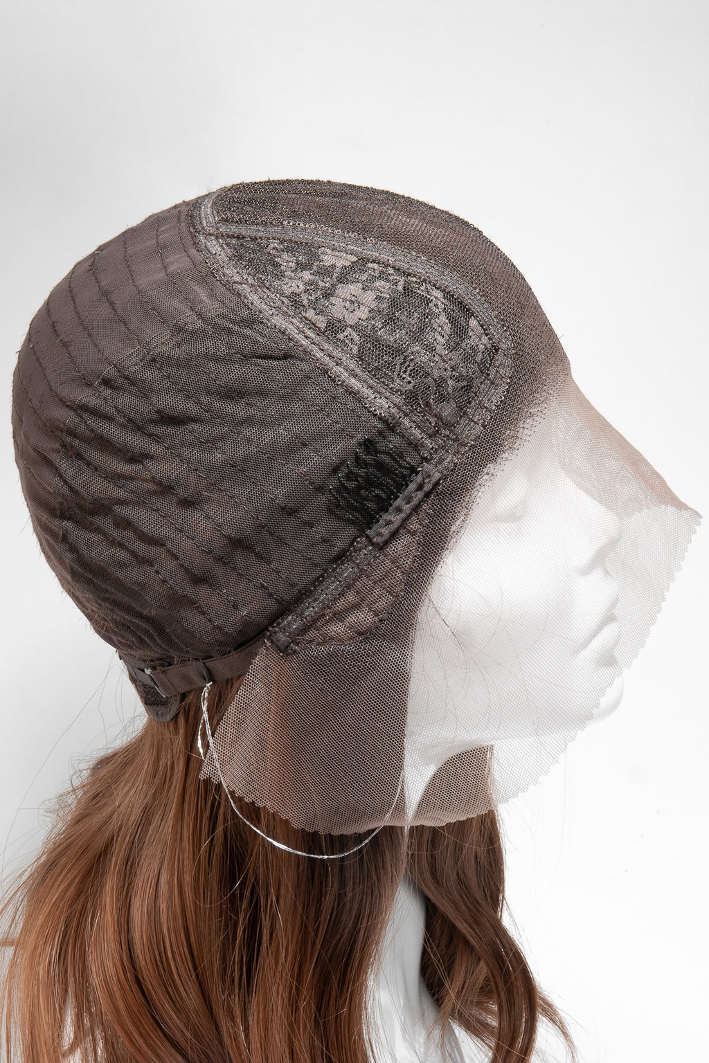 ärbild på perukens lace med spännen, i en brun naturlig färg, som visar detaljerad textur och säker fastsättning för en bekväm och stabil passform