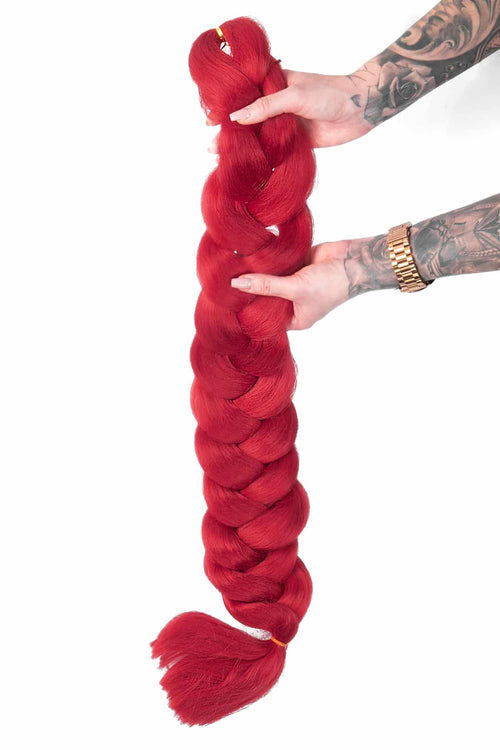 Röd box braids fläthår i syntetiskt material, där löshåret är flätat in för att skapa täta och hållbara box braids med en stark och iögonfallande färg
