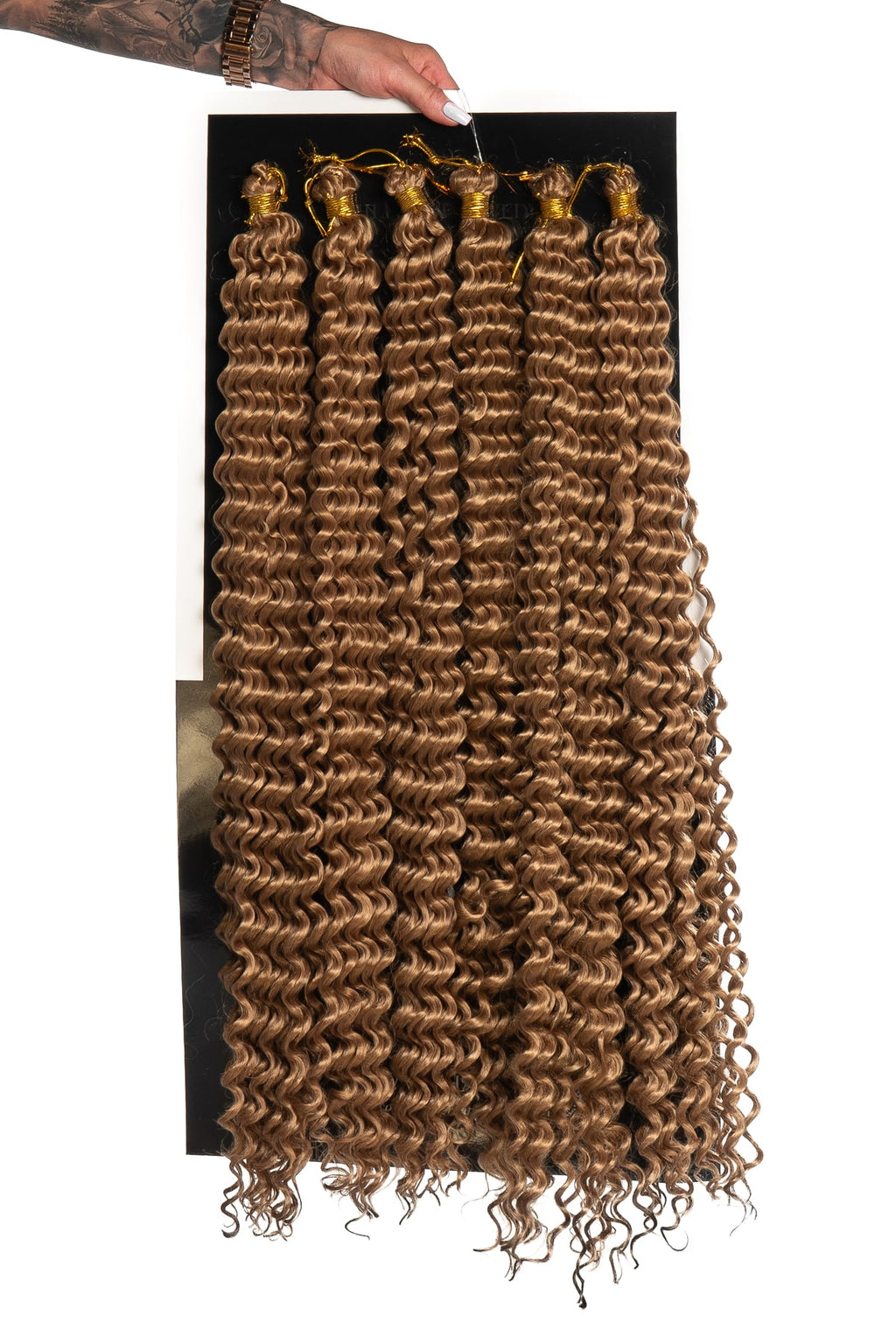 Fylligt lockigt hår i karamell brun färg med täta lockar. Perfekt för flätor, twists eller voluminösa frisyrer med naturlig rörelse och glans.