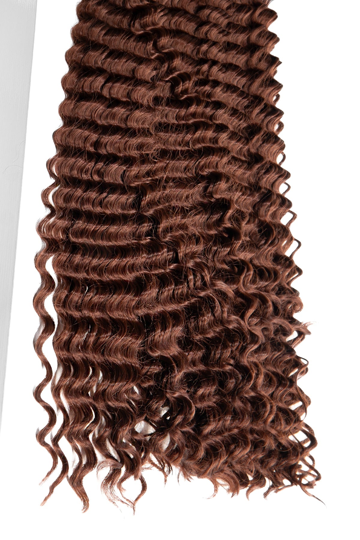 Lockigt syntetiskt boho hår i varm brun färg med täta, spiralformade goddess lockar. Perfekt för flätor eller crochet stilar med naturlig volym och silkeslen glans.