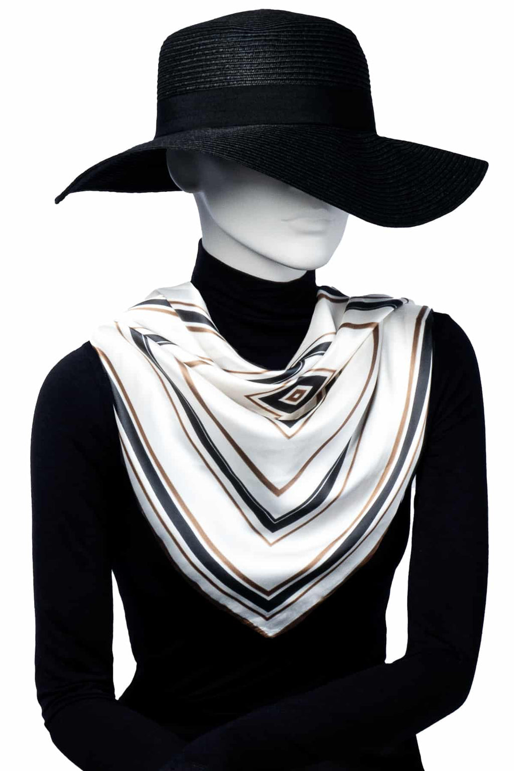 Mannequin i svart hatt och polotröja bär en elegant scarf med diagonala ränder i vitt, svart, beige och brunt, knuten löst runt halsen.