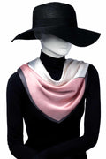 Scarf hänger löst runt hals på docka. Grå, rosa och vita färger i block.