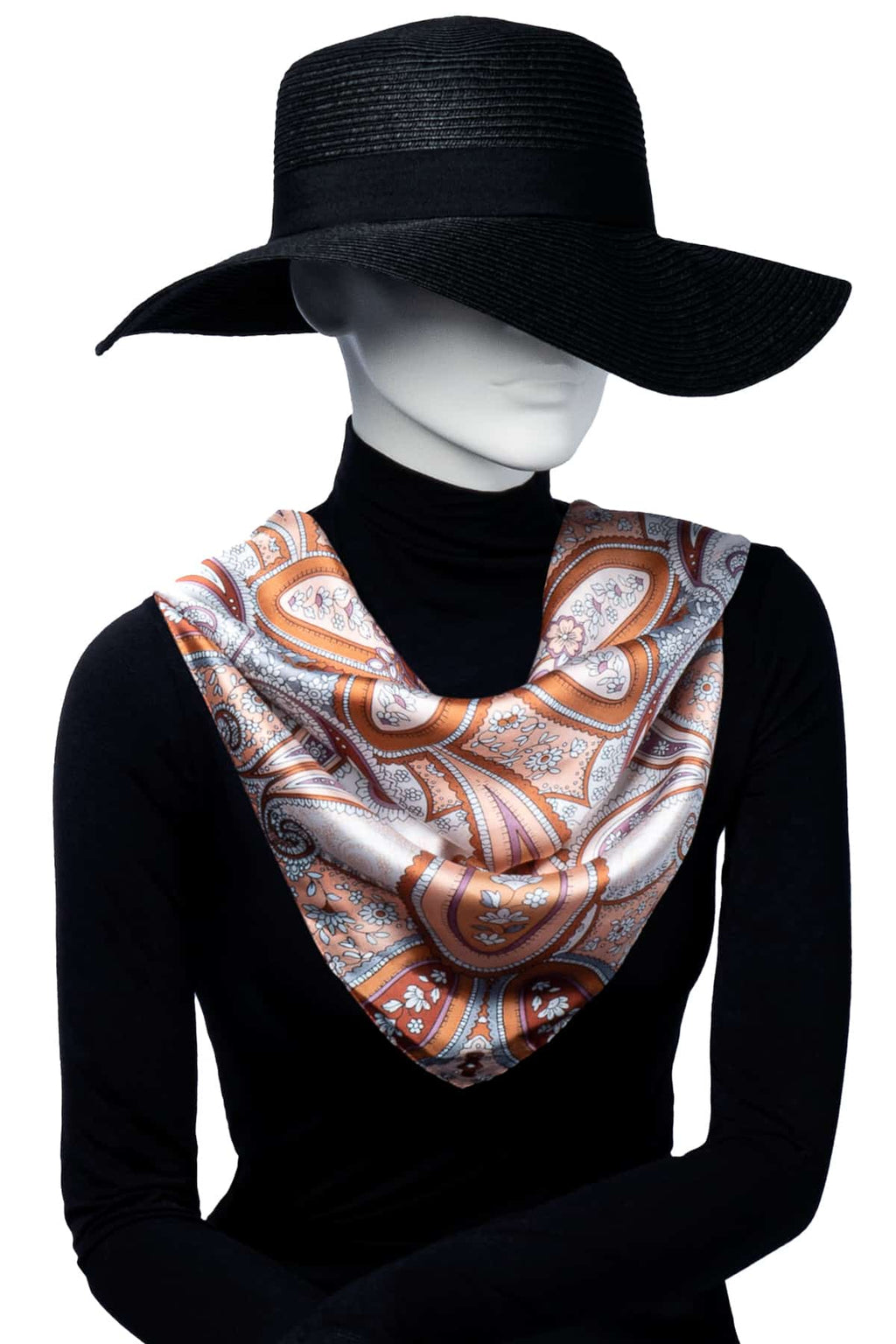 Paisleymönstrad scarf i varma nyanser av orange, rosa och vitt, hänger runt halsen.