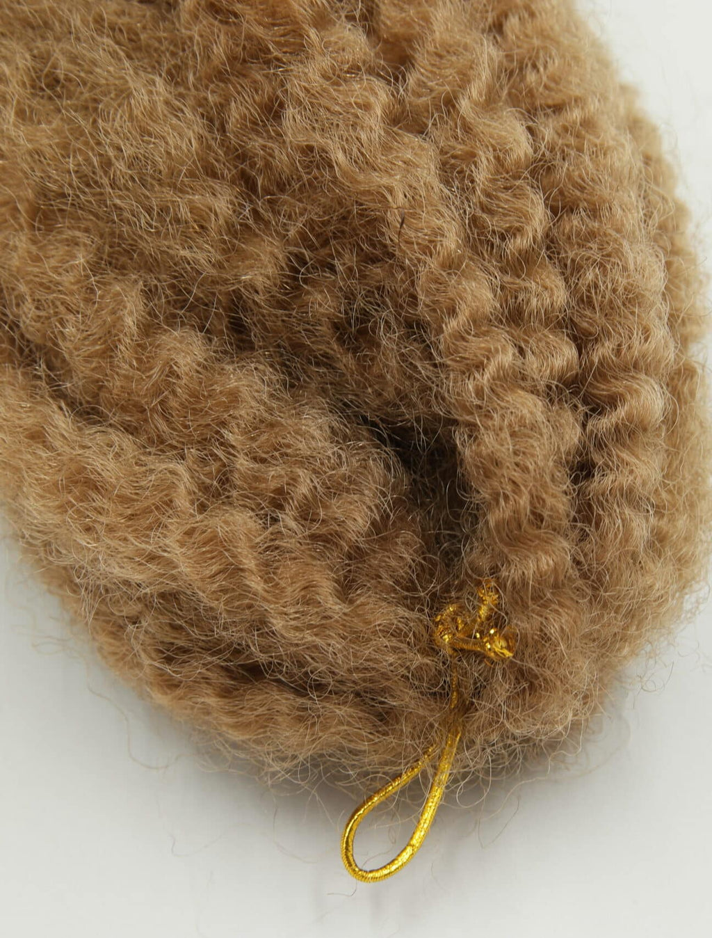 Närbild på afro kinky braids i varm ljusbrun nyans (färg 27), där flätorna är täta och små med textur som efterliknar naturligt afro-texturerat hår