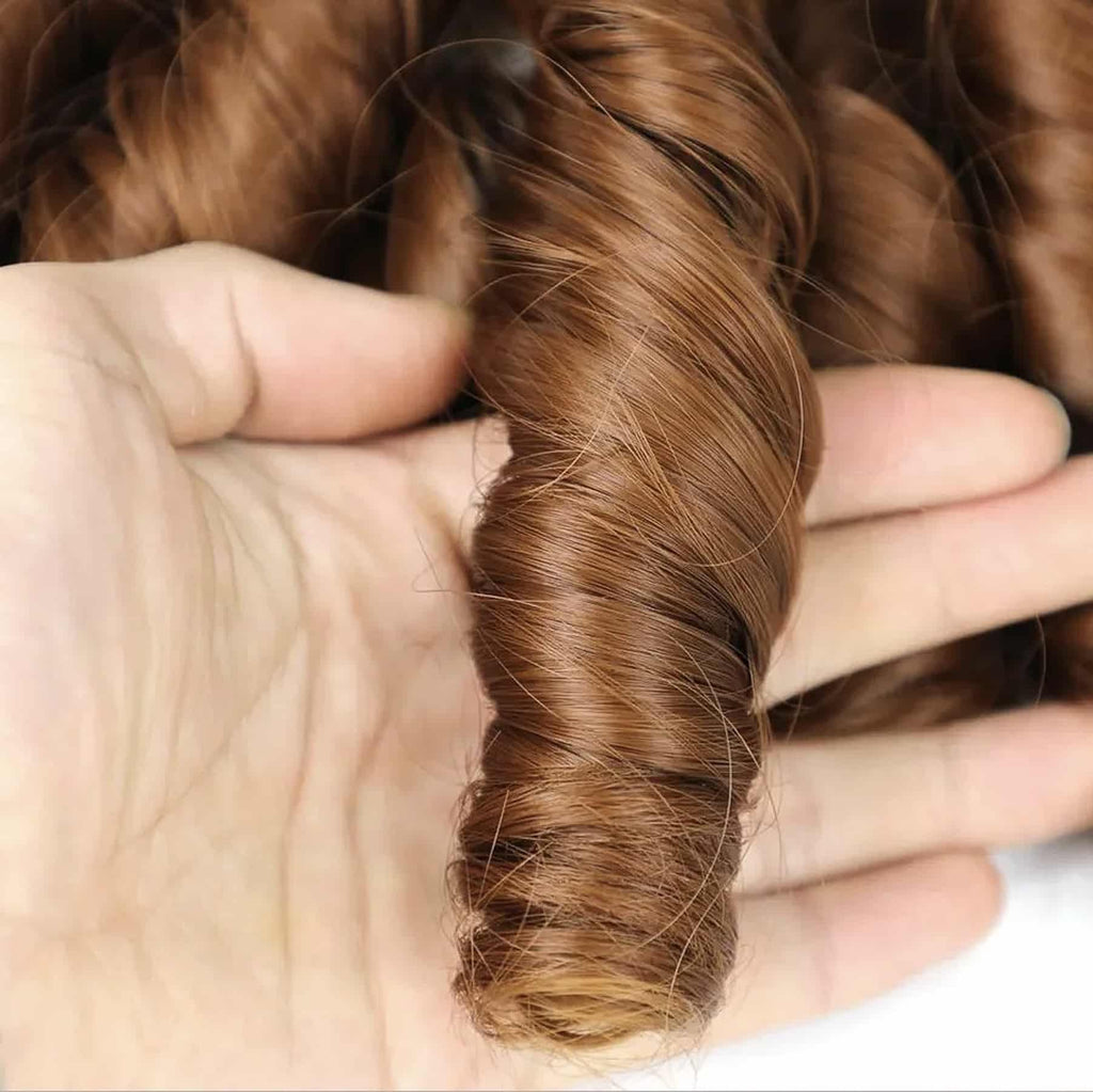 Glansigt syntetiskt hår i varm kastanjebrun ton med definierade spirallockar. Mjuk, följsam textur som reflekterar ljuset naturligt för en elegant finish.