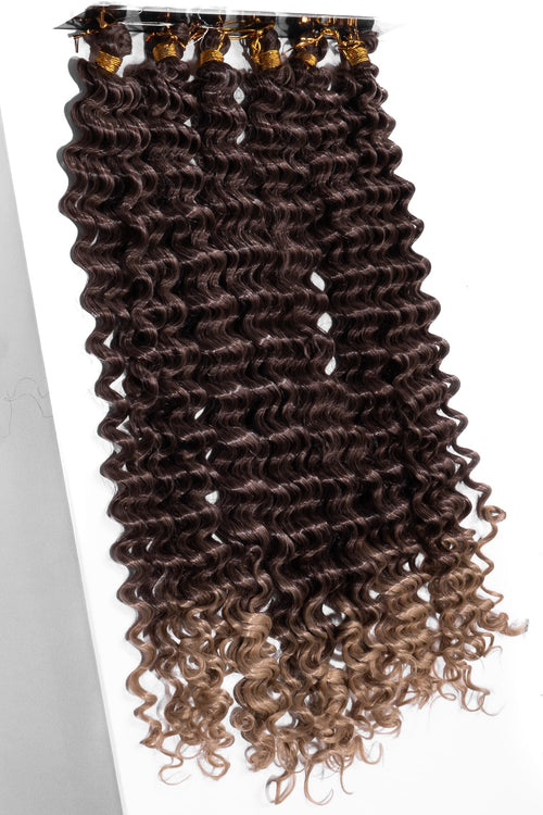 Syntetiskt boho braids hår i sexpack med glänsande, lätta lockar. Färgen övergår från djup brun till varm karamellblond för en naturlig, solkysst look.