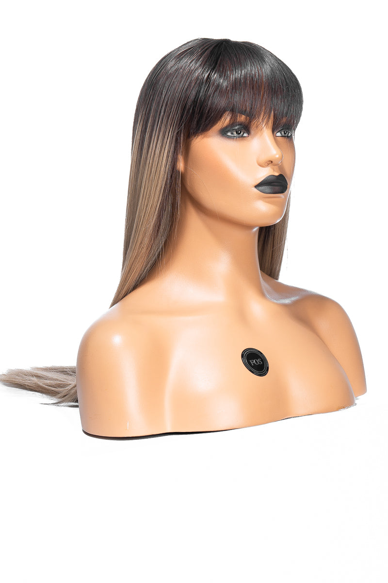 Mannekäng med ljusbrun peruk med mörka rötter och lugg, bär svart läppstift