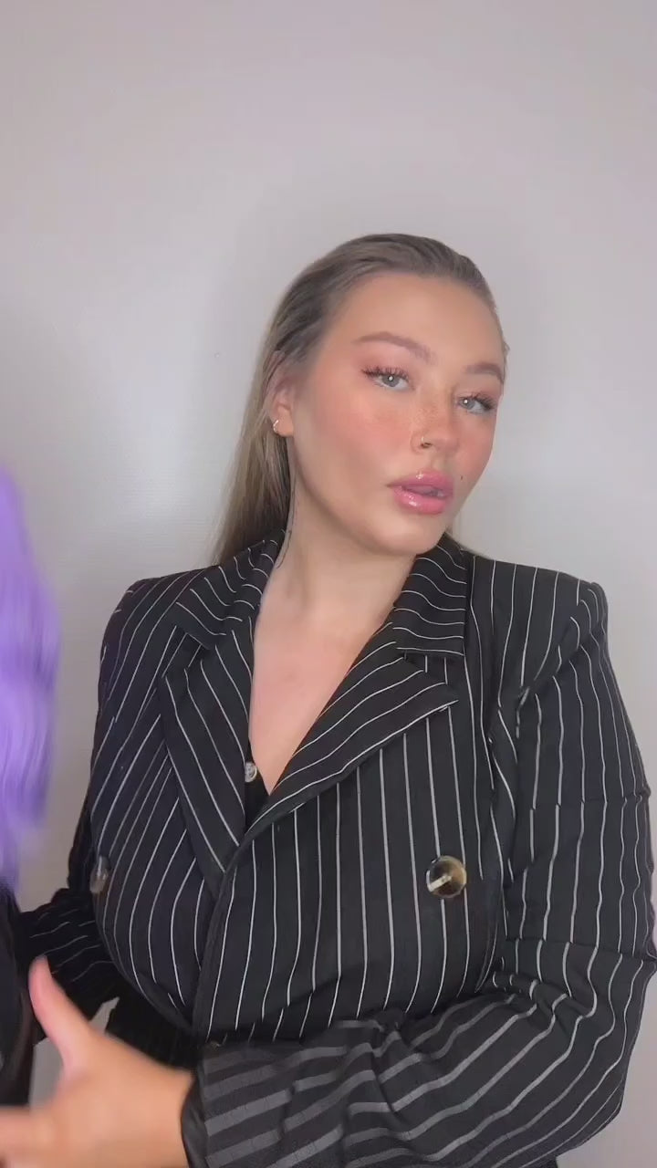 Kvinna visar upp och poserar iförd FOS Hair peruk IRIS. En lila bob.